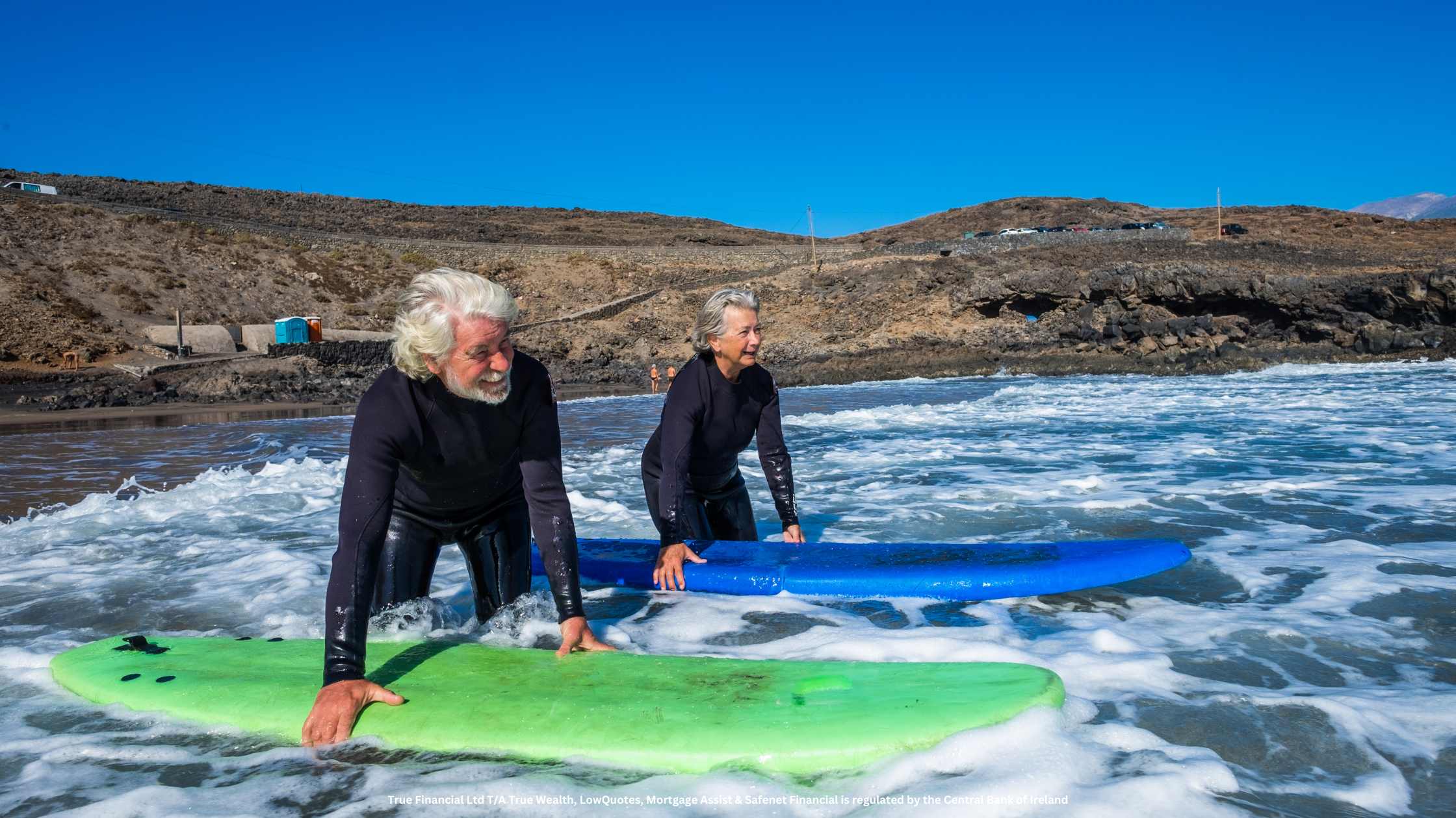 old couple surfing at the beach